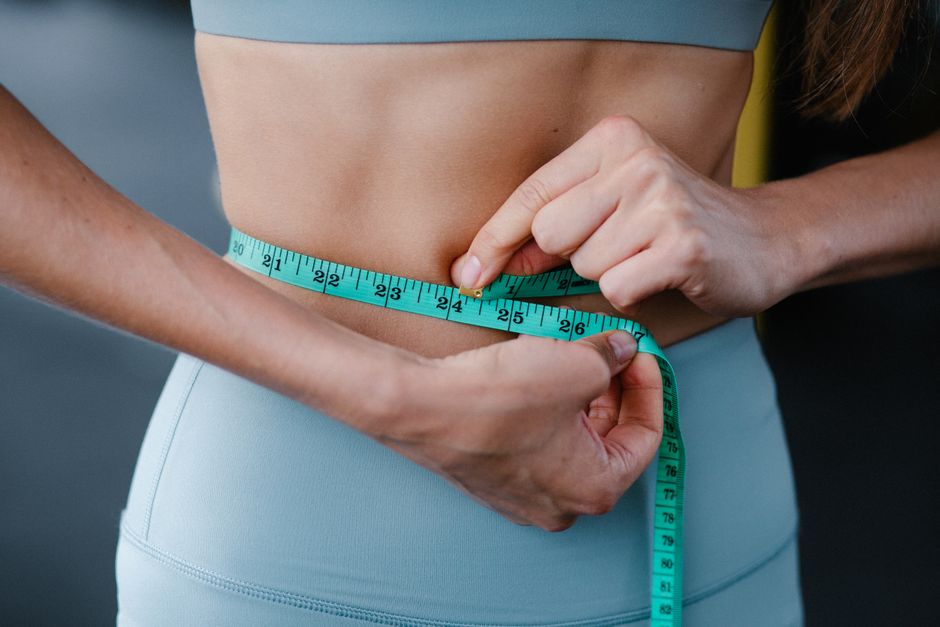 Tape measure around a waist tracking weight loss progress