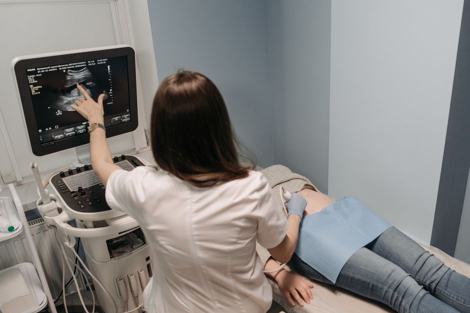 Physician examining a patient's abdomen during a consultation