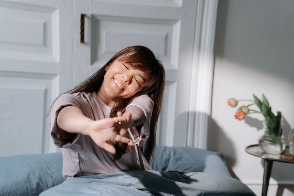 Woman waking up feeling rested after improved sleep quality
